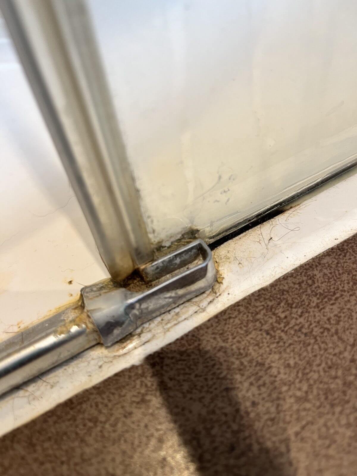 Rail de porte de douche encrassé avant nettoyage à la vapeur sèche, à Guérande